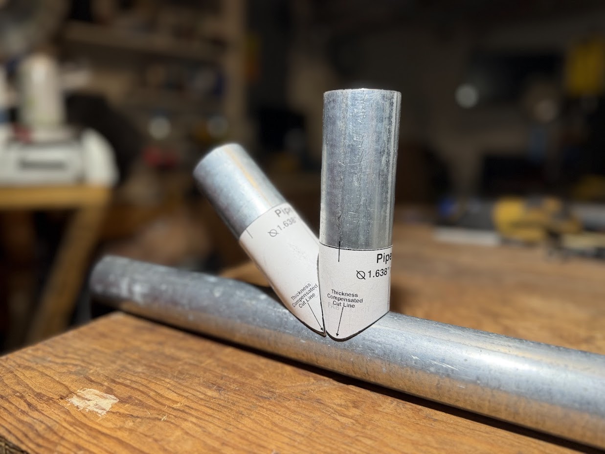 Pipes with printed templates wrapped around them, ready for cutting.